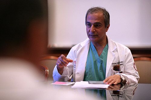 Physician advises others inside of a conference room.